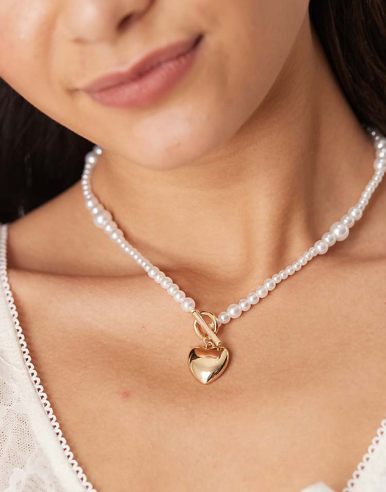 https://images.asos-media.com/products/asos-design-short-necklace-with-pearl-heart-detail-in-gold-tone/207909702-1-gold?$n_750w$&wid=750&fit=constrain