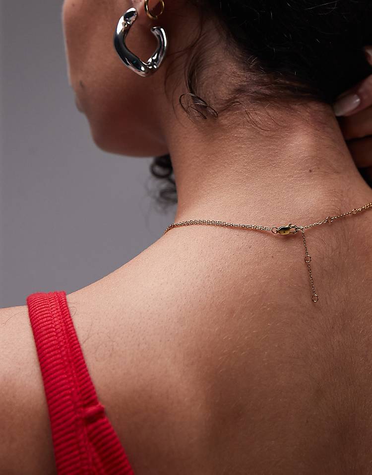 https://images.asos-media.com/products/topshop-seti-waterproof-stainless-steel-lariat-chain-necklace-in-gold/208532375-2?$n_750w$&wid=750&fit=constrain