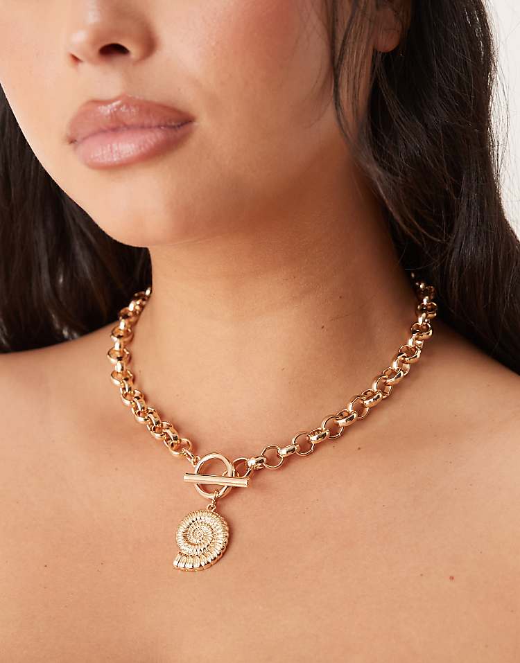 https://images.asos-media.com/products/asos-design-curve-necklace-with-tbar-and-shell-charm-detail-in-gold-tone/208540263-1-gold?$n_750w$&wid=750&fit=constrain